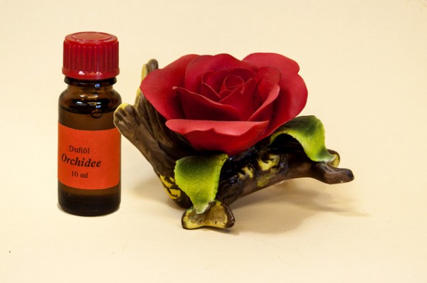 Porzellan Blume, Blüte rot mit einer Flasche Duftöl